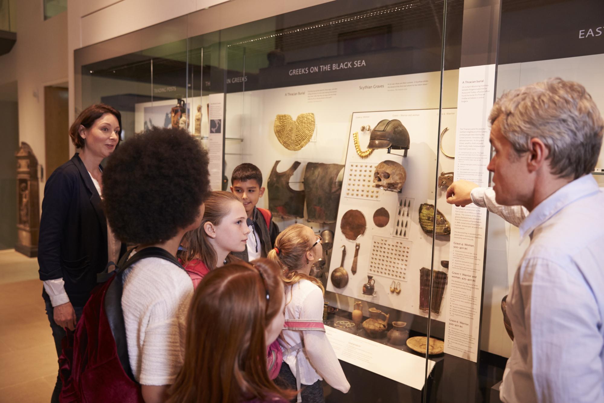 Kids Looking At Artifacts In Case On Trip To Museum