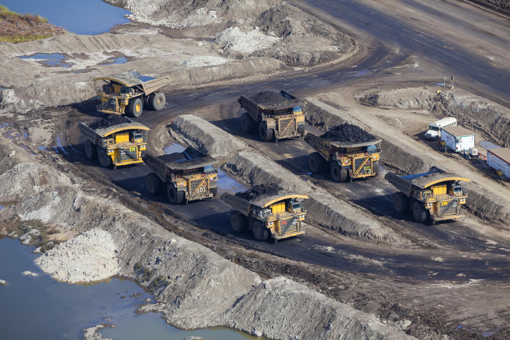 Aerial photo of a large dump trucks parked at a mine staging area