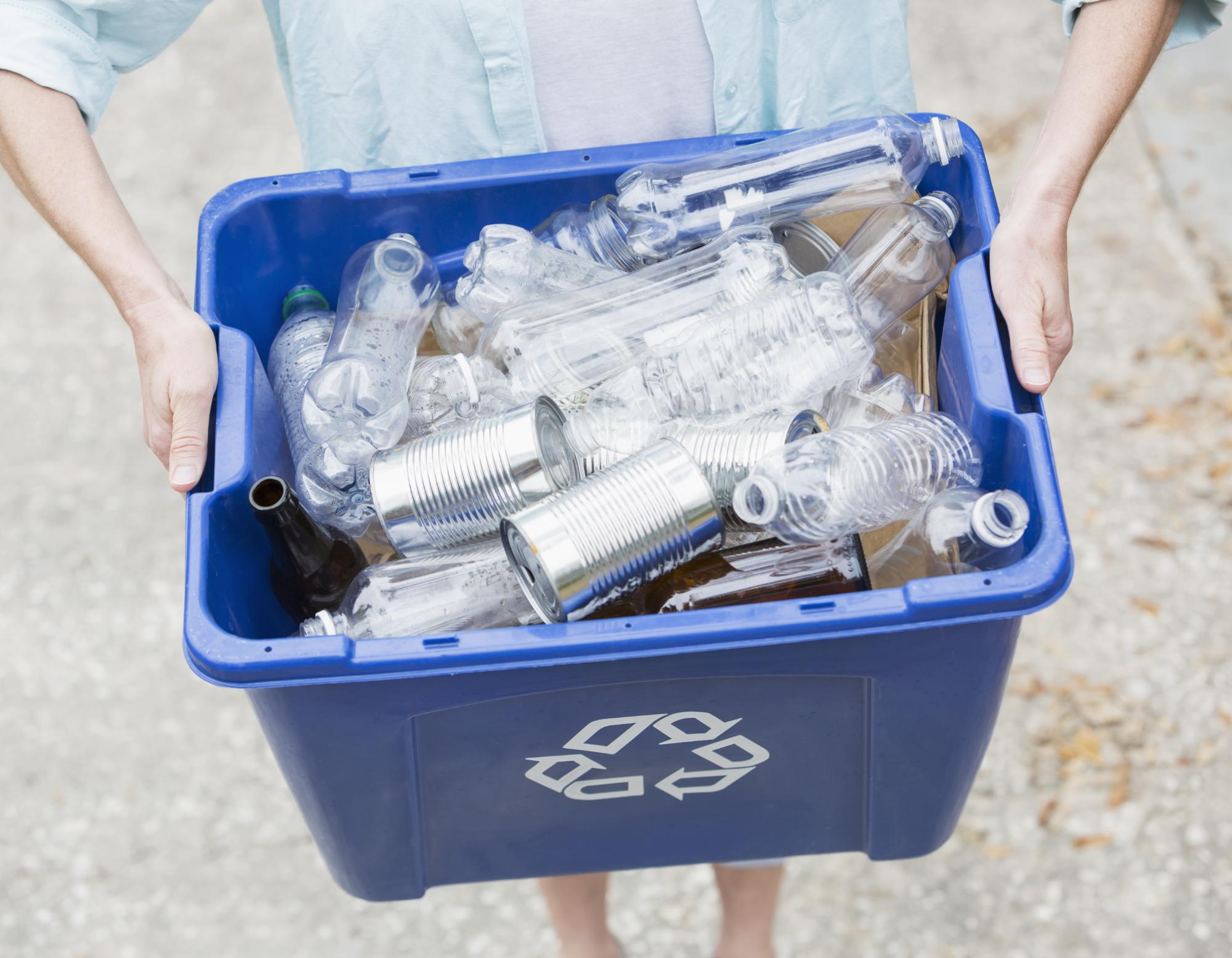 Woman carrying recycle bin