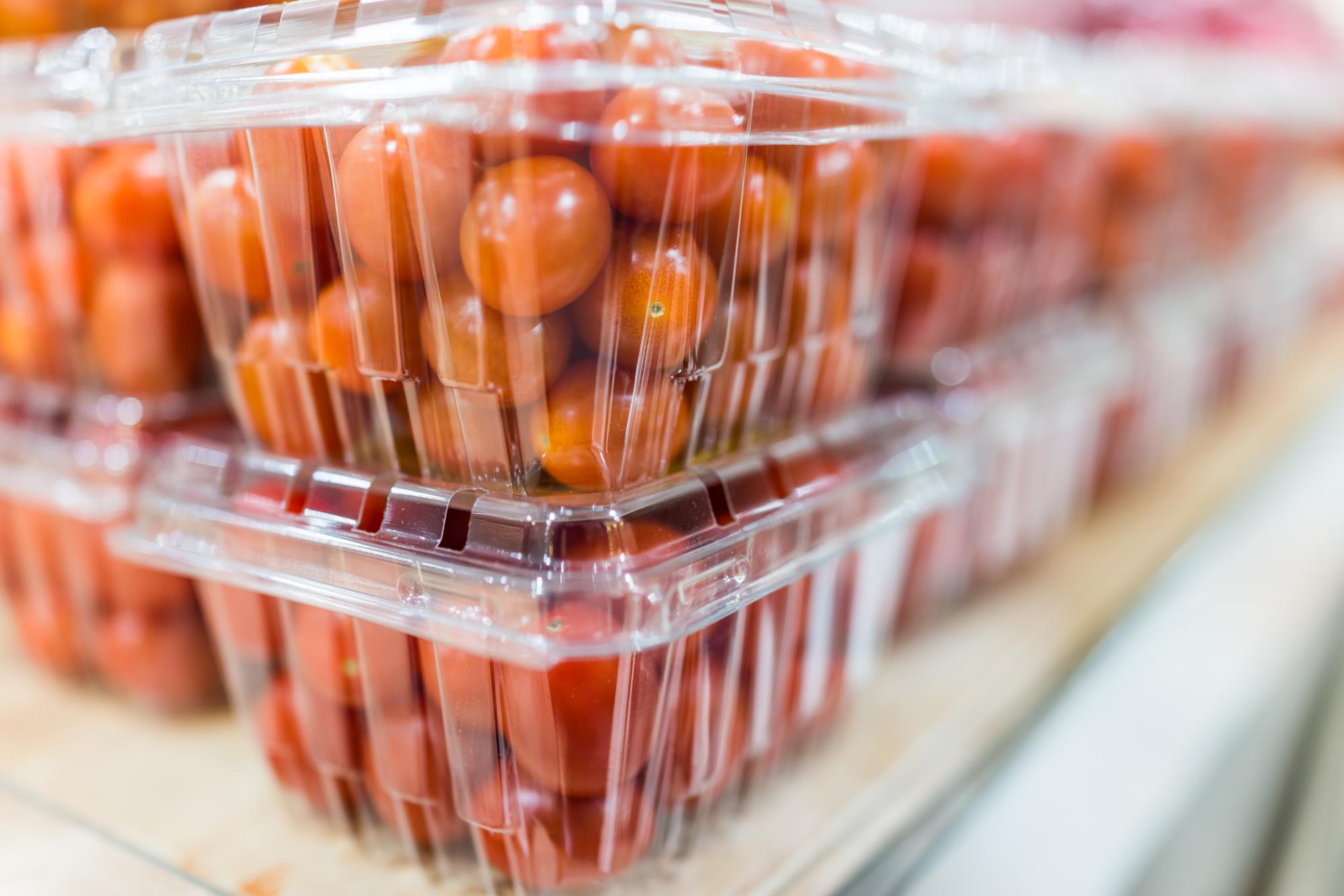 Cherry tomatoes in plastic boxes on display