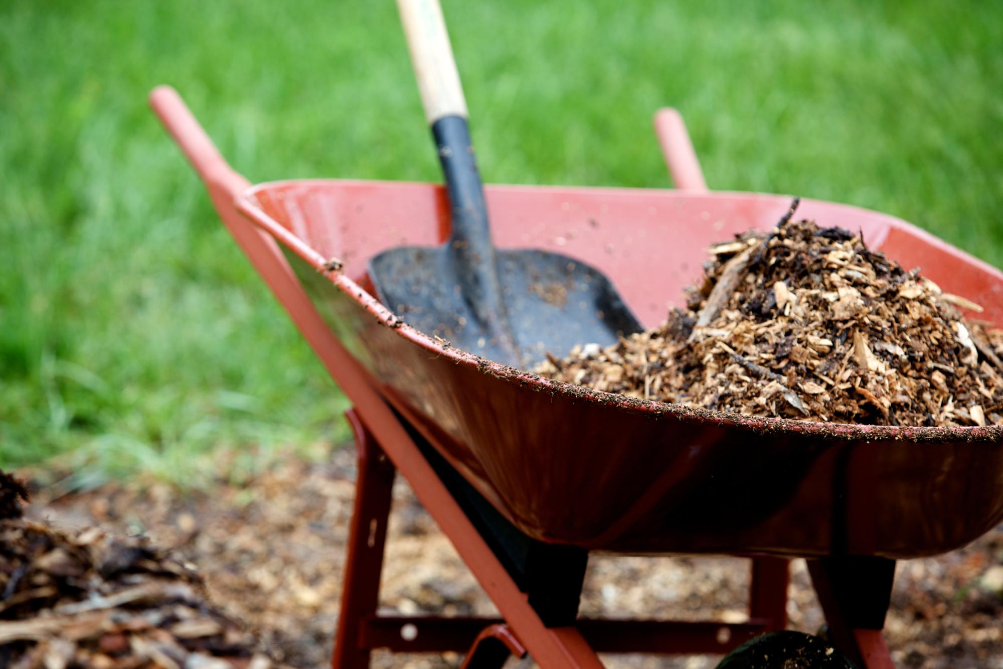 wheel barrow and shovel working with landscape mulch