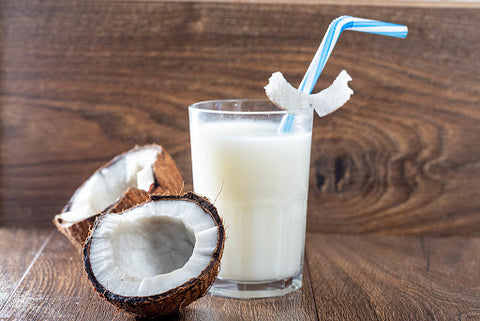 Coconut milk with coconuts next to it