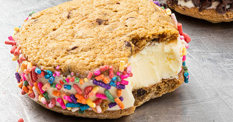 A close up of vanilla vegan ice cream sandwich with sprinkles around it