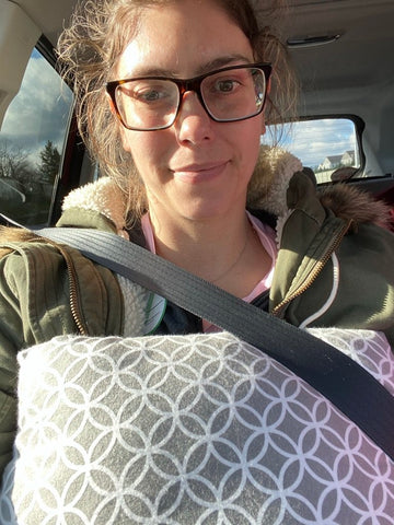 woman in car with mastectomy pillow and seat belt