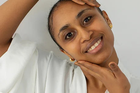 Picture of smiling indian woman with pure skin, gently touching her face