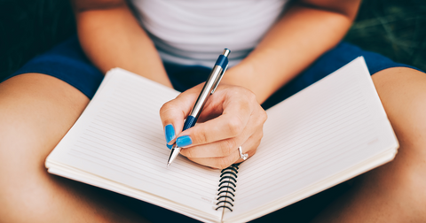 A person writing in a journal to practise mindfulness