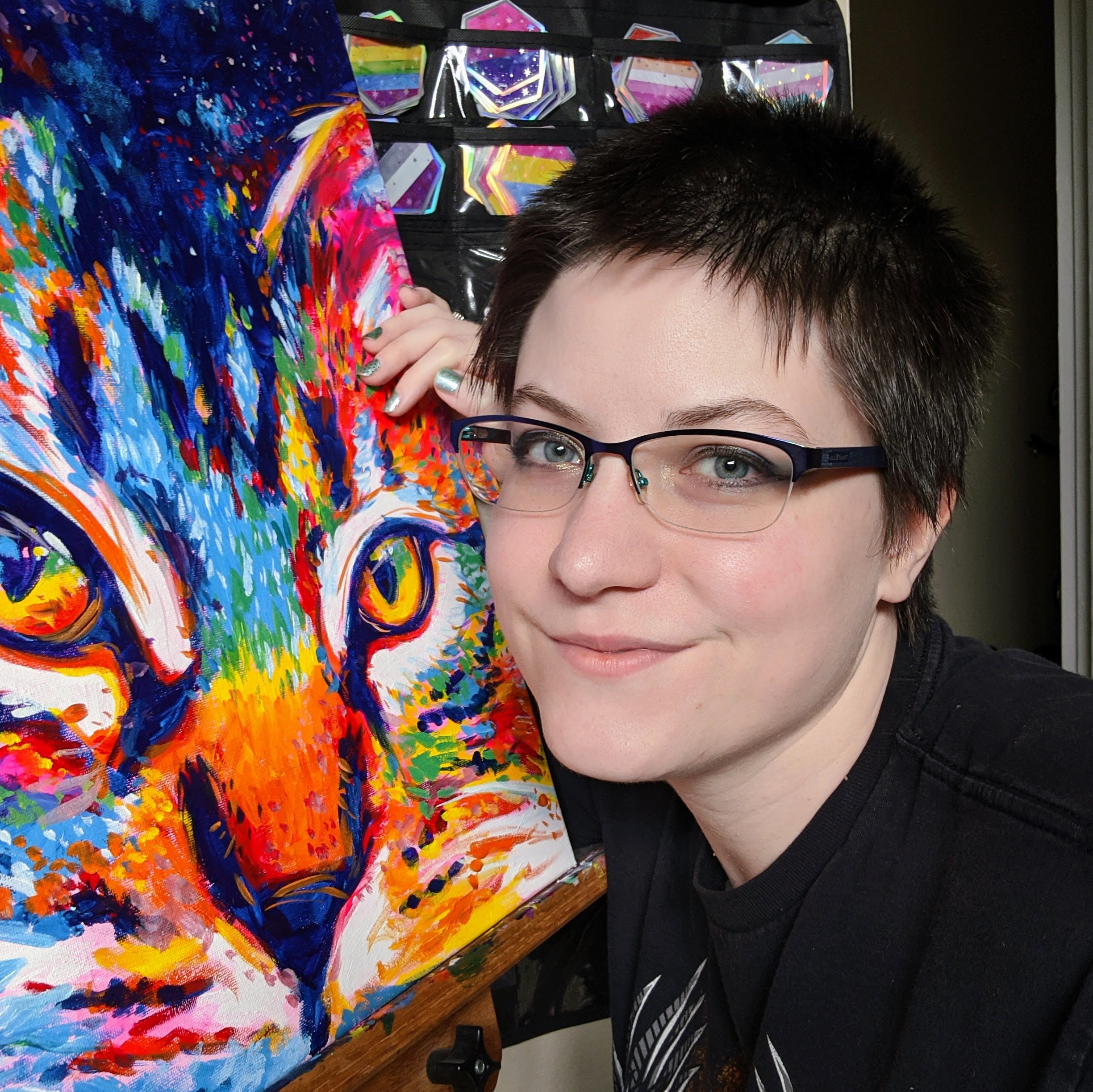 Photo of the artist Kelli, next to a vibrant painting of a cat
