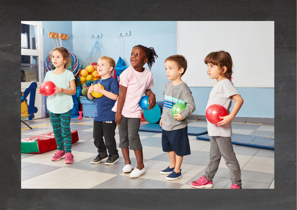 Idee Kindergeburtstagslocation: Turnhalle. Kinder stehen in einer Turnhalle mit Bällen in einer Reihe