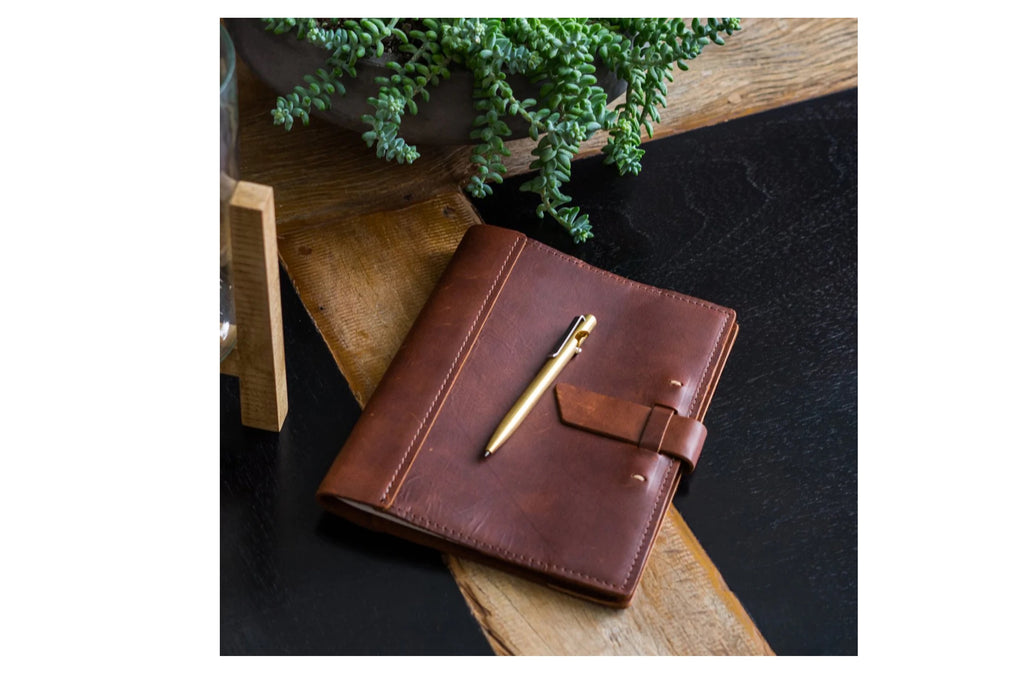 Dark brown leatherbound journal with golden pen