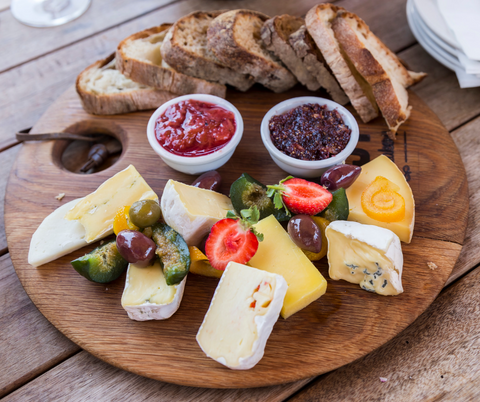 Charcuterie board with cheeses, deli meats, fruit and Mad Mountain sweet chilli sauce