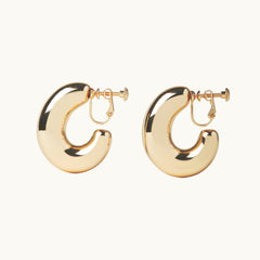 Image of the Chunky Oval Hoop Clip On Earrings in Gold - the perfect solution for those with thick, large, sensitive, small, thin, or keloid prone ears. With a convenient screwback clip-on closure, these earrings can be manually adjusted for a secure and comfortable fit that lasts up to 12 hours. This single pair is the perfect addition to any jewelry collection.