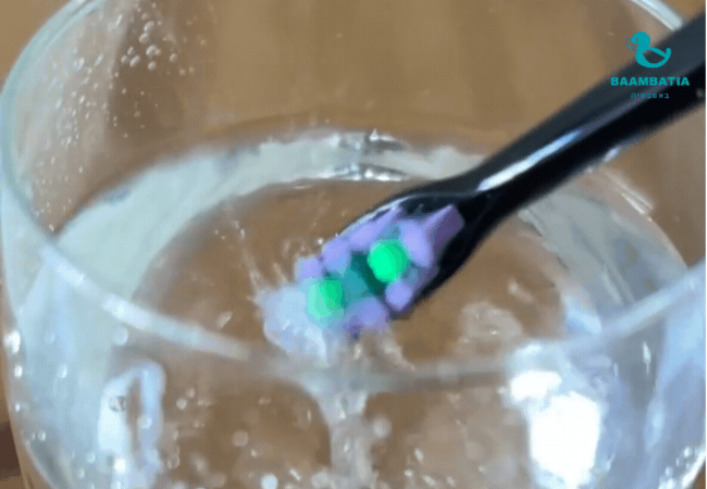 מברשת עושה בועות בתוך כוס של מים