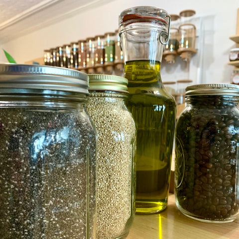 various glass jars filled with dry goods and oils