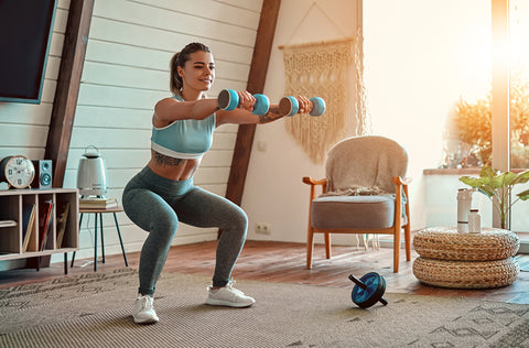 Woman wearing leggings completing workout at home