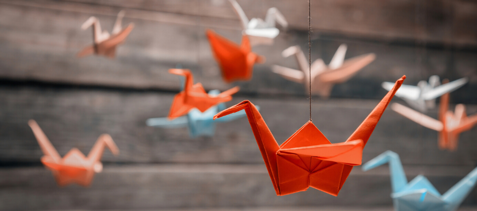 Several Folded Origami Paper Cranes Hanging on Thread