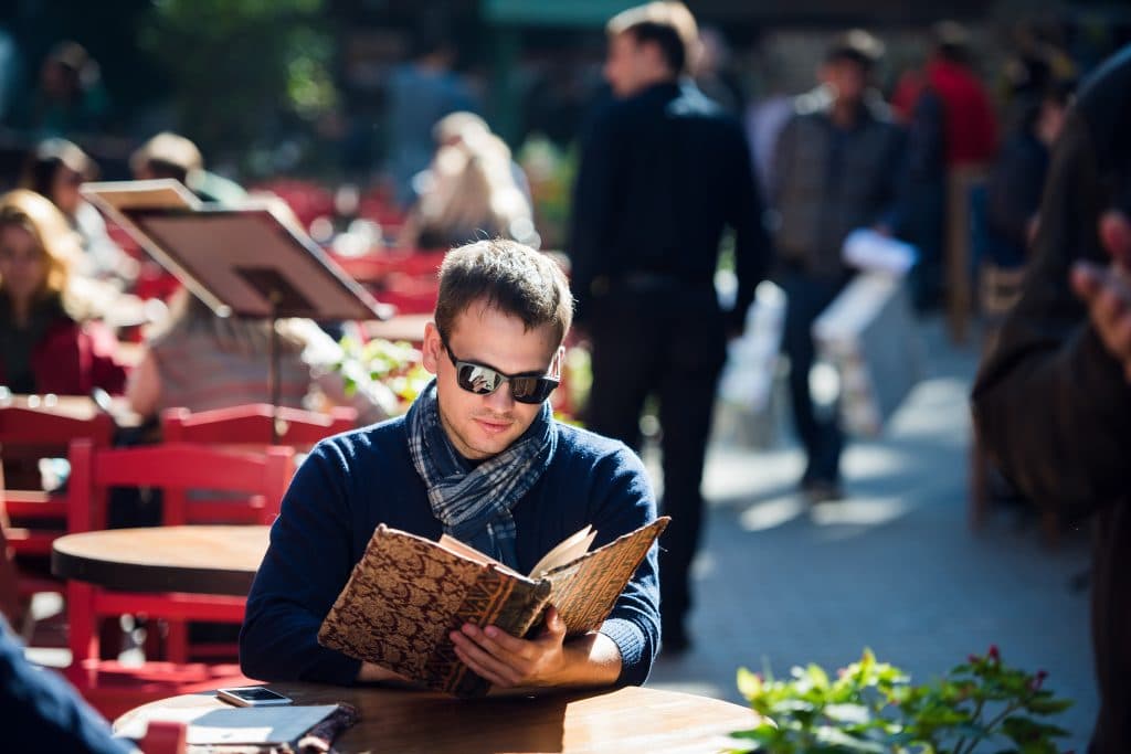 Young handsome man looking at the menu outdoors