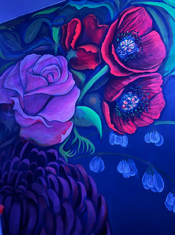 A floral mural at night with UV light revealing hidden highlights and details: vibrant red poppies on glowing green stems, a hot pink rose, blue white snow bells, and a vibrant violet mum.