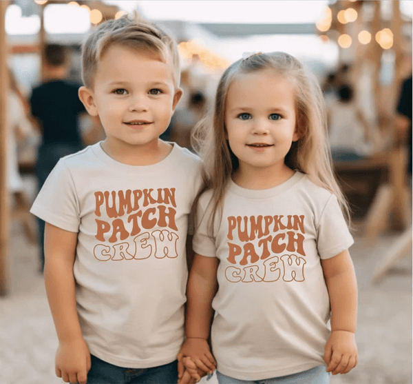A brother and sister wearing matching Thanksgiving outfits that read Pumpkin Patch Crew