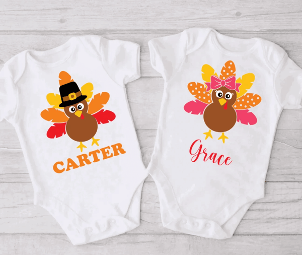Two white customized bodysuits for brother and sister. Left bodysuit has a boy turkey and the name Carter printed on it. Right bodysuit has a girl turkey drawing and the name Grace printed on it.