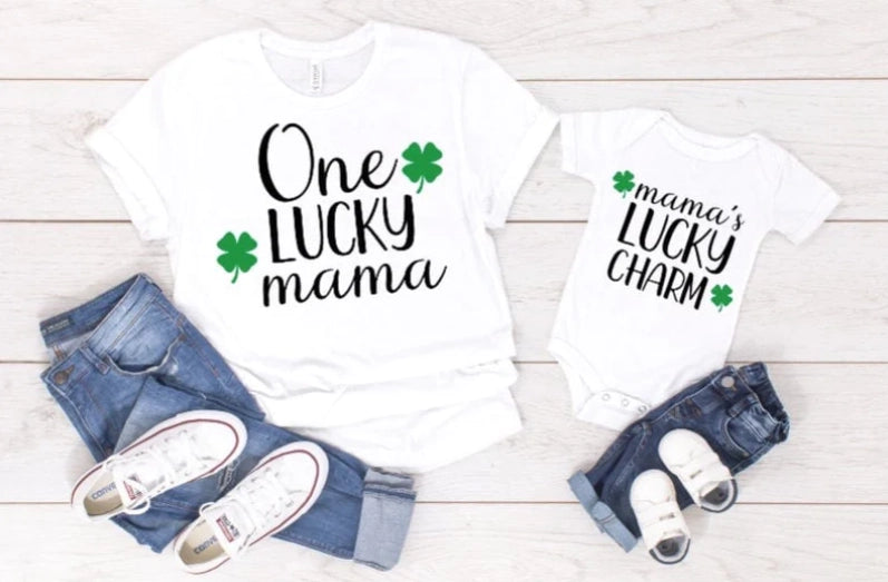 Matching St. Patty's Day outfits for moms and kids. One Lucky Mama is printed on the mommy shirt and Mama's Lucky Charm on the baby girl/boy bodysuit