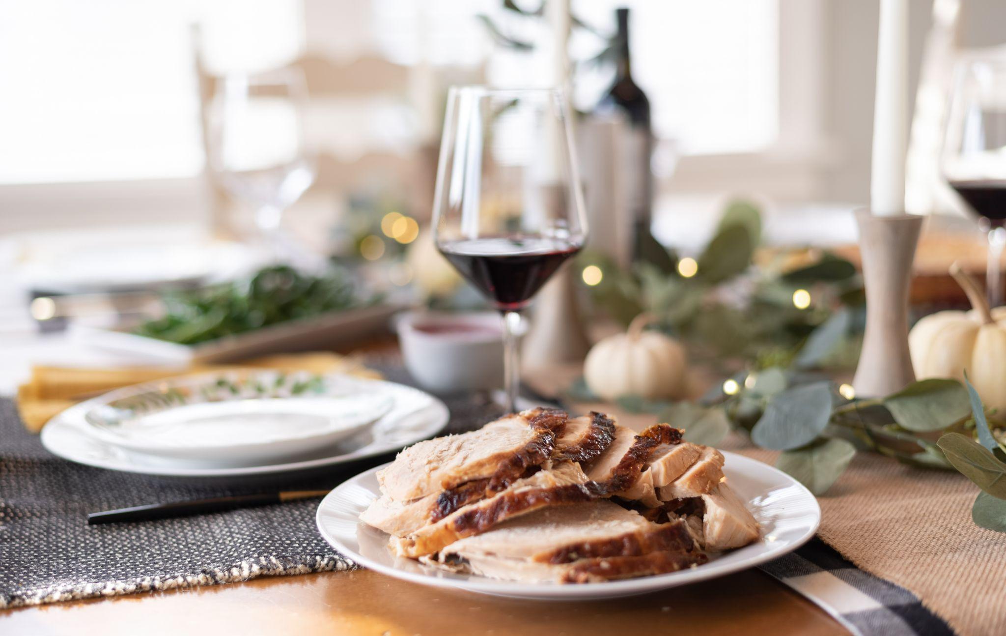 Plate of sliced turkey with red wine in blurred background