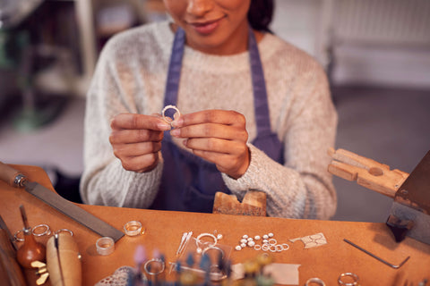 A female jeweler inspects a custom ring