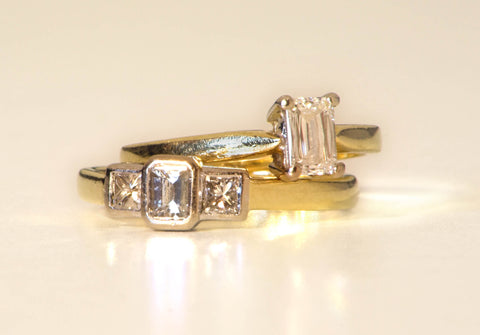 two vintage gold engagement rings with asscher cut diamonds