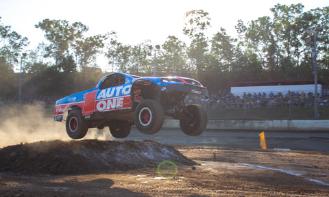 A trophy truck launches off a dirt jump at Darwin Speedway