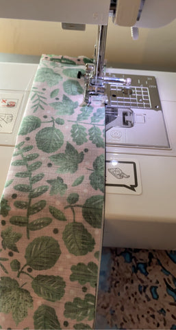 sewing the strip of fabric on a machine for a make your own scrunchie