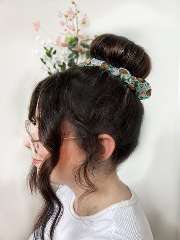 dark haired girl wears a bun with hedgehog patterned scrunchie