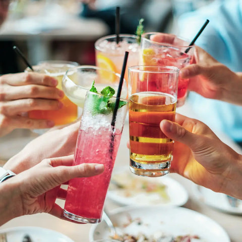 a image of a groups of friends clinking glasses which are filled with summery looking drinks