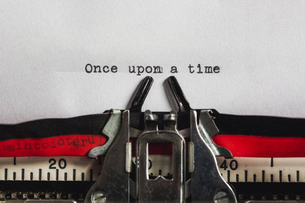 A picture of a typewriter. The typewriter has a sheet of paper inserted and typed on the page are the words 'Once upon a time..'