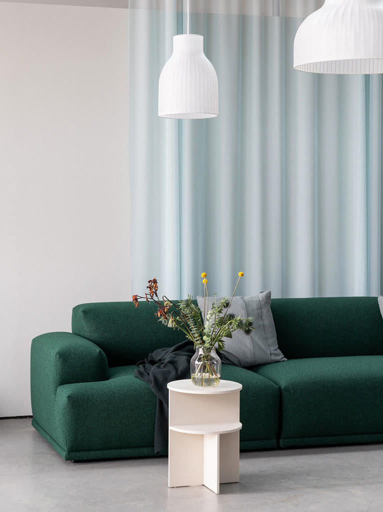深綠的客廳沙發配色在白色牆面映襯下展現一種自然親和且沈穩的氣質