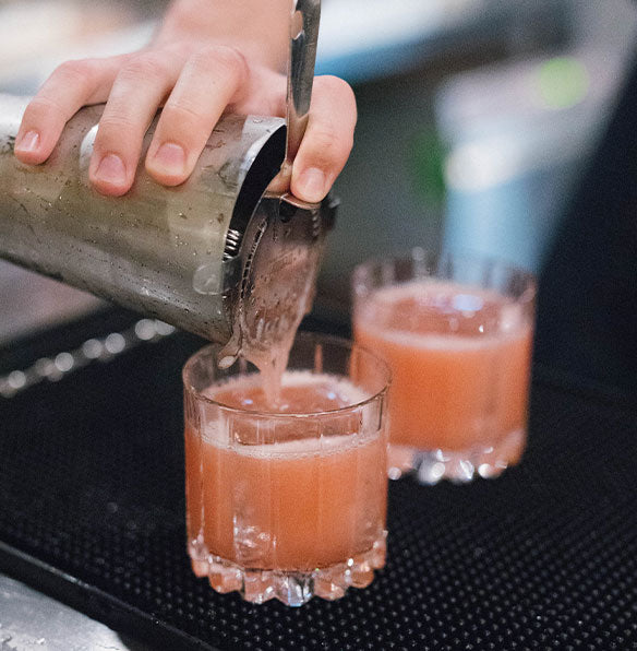 Image of two cocktails being poured from a shaker