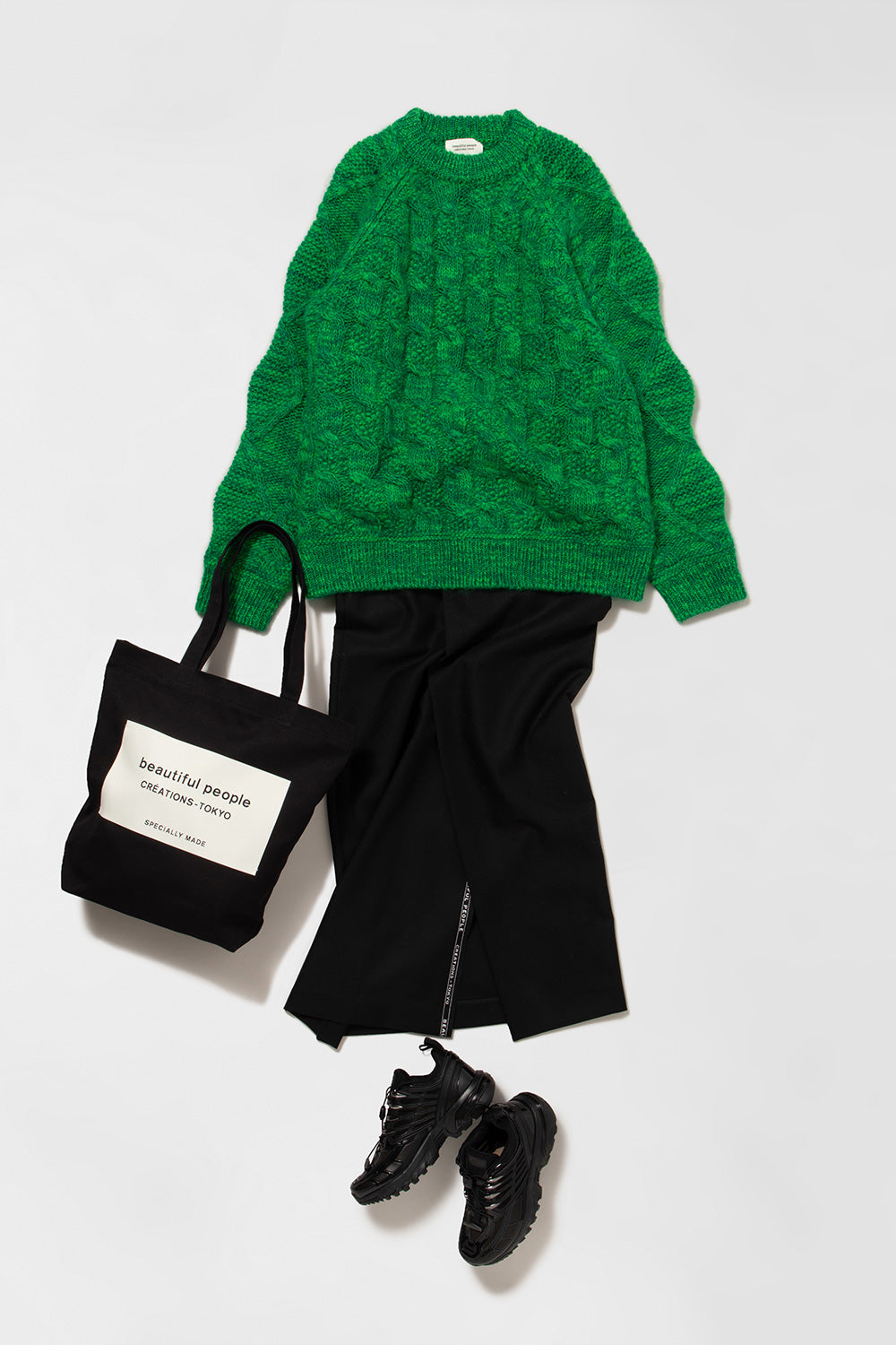 ビューティフルピープルの緑のニットに黒いスカートとバッグを合わせたスタイリング