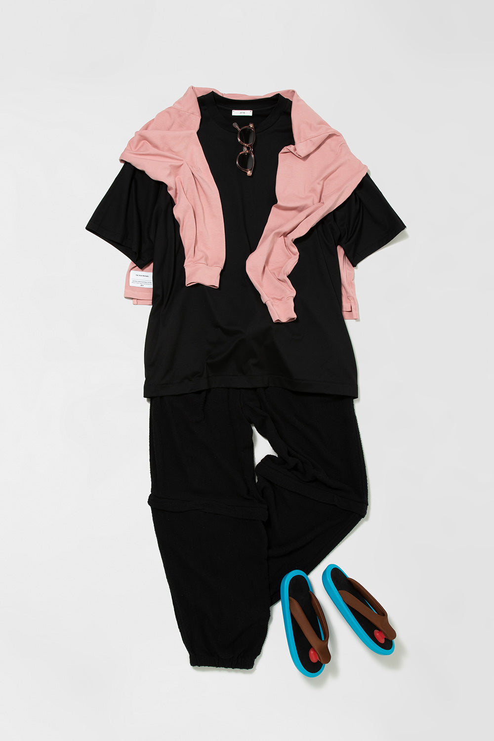 イノウエブラザーズのピンクのロングTシャツとエイトンの黒いTシャツにコモリのパンツを合わせたスタイリング