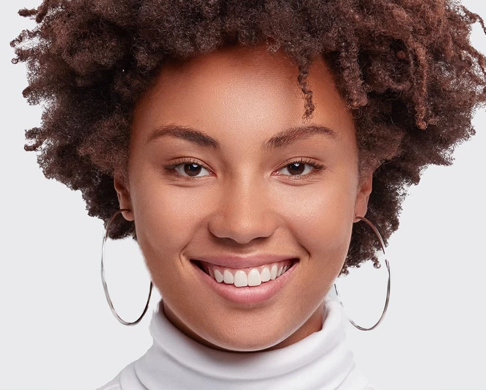 smiling young woman of color with healthy eyes