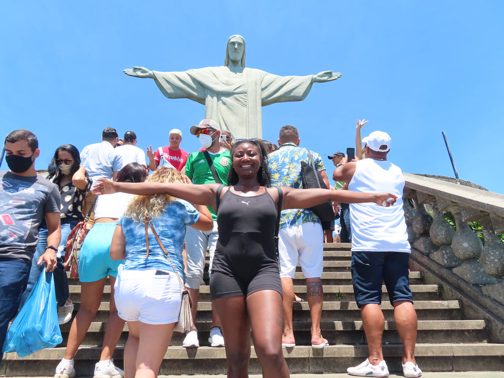 Solo travel girl posing with Christ the Redeemer in Brazil