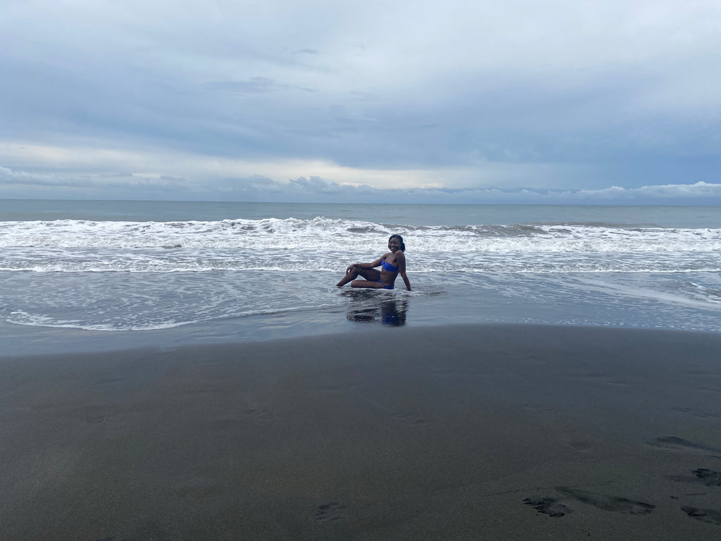 Solo travel girl sitting on Playa Negra beach