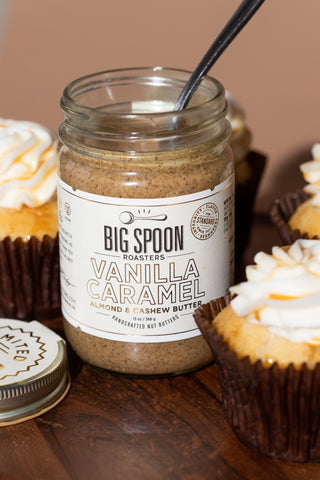A jar of Limited Batch Vanilla Caramel is open and surrounded by Vanilla Caramel cupcakes