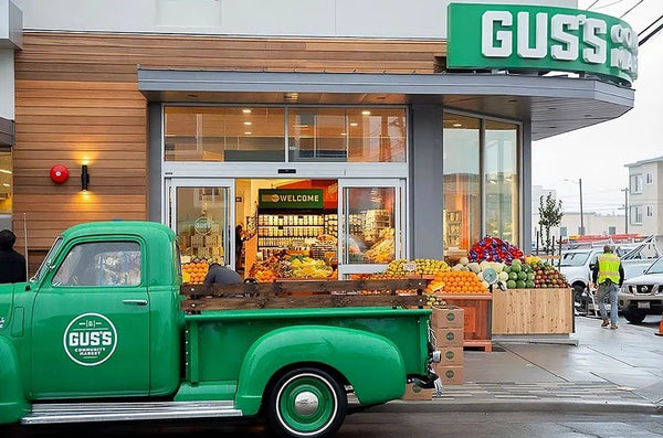 Gus's market exterior photo with green truck in front.