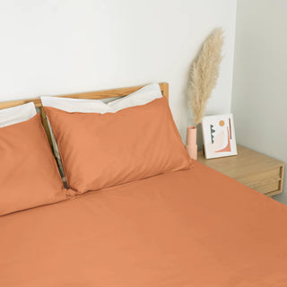 Homebird Organic Percale Fitted Sheet and Pillowcases - staged bed #colour_clay