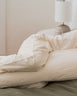 image showing a body pillow positioned between the knees of someone sleeping on their side