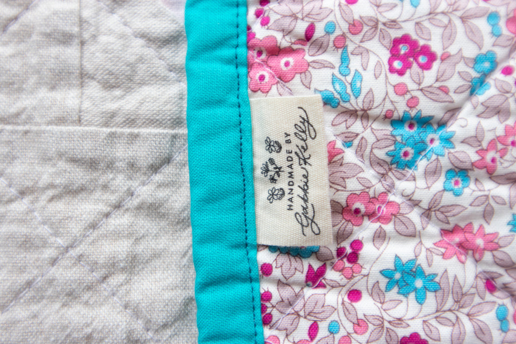 Detail of quilt binding with Handmade by Gabbie Kelly tag