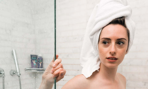 girl in hair towel getting out of shower