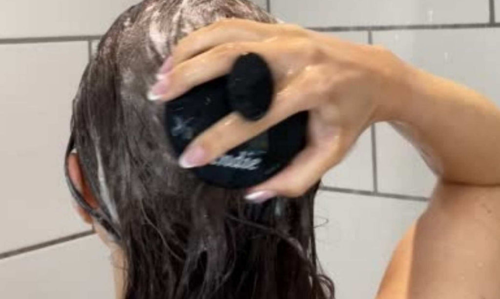 girl shampooing with scalp massager brush