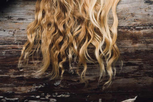 blonde hair draped over log