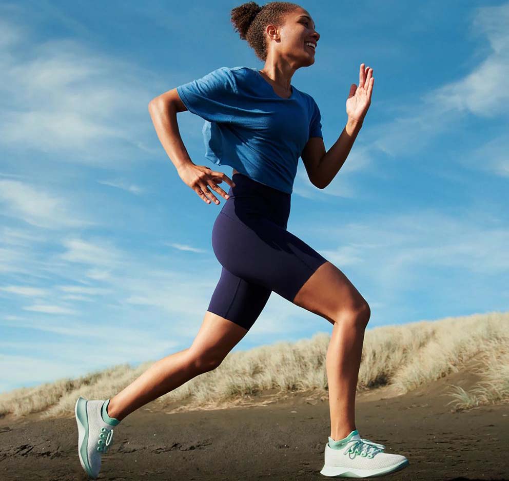 A woman running while wearing reruns shows from Allbirds