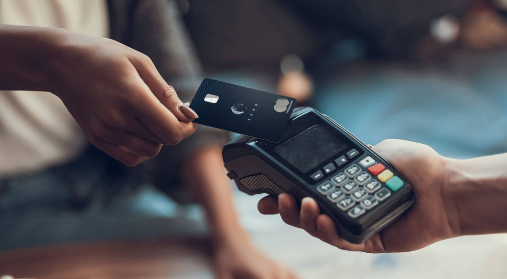 A woman paying with a credit card from Aspiration