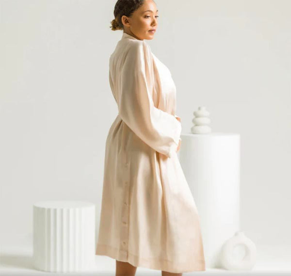 A woman wearing an off-white robe